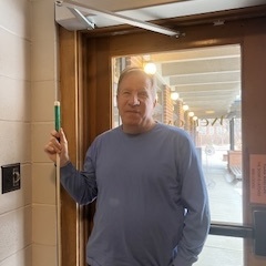 Bob Burns facing the camera while holding a cane.